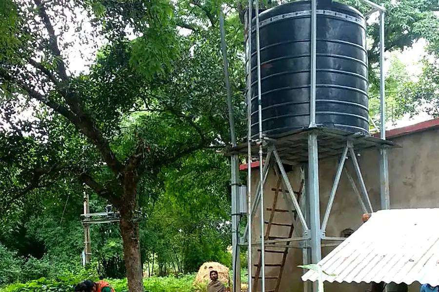 Village community collecting water from solar-powered tank system