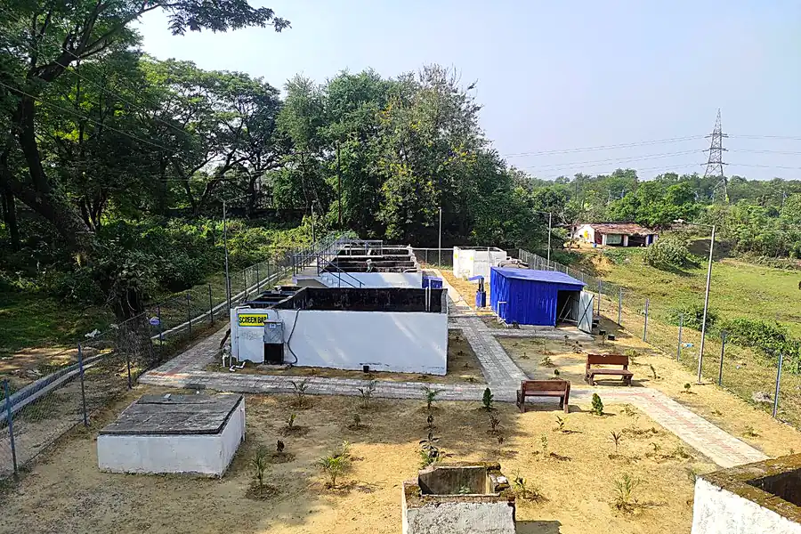 Sewage treatment plant with treatment tanks, screen bar chamber and landscaped compound